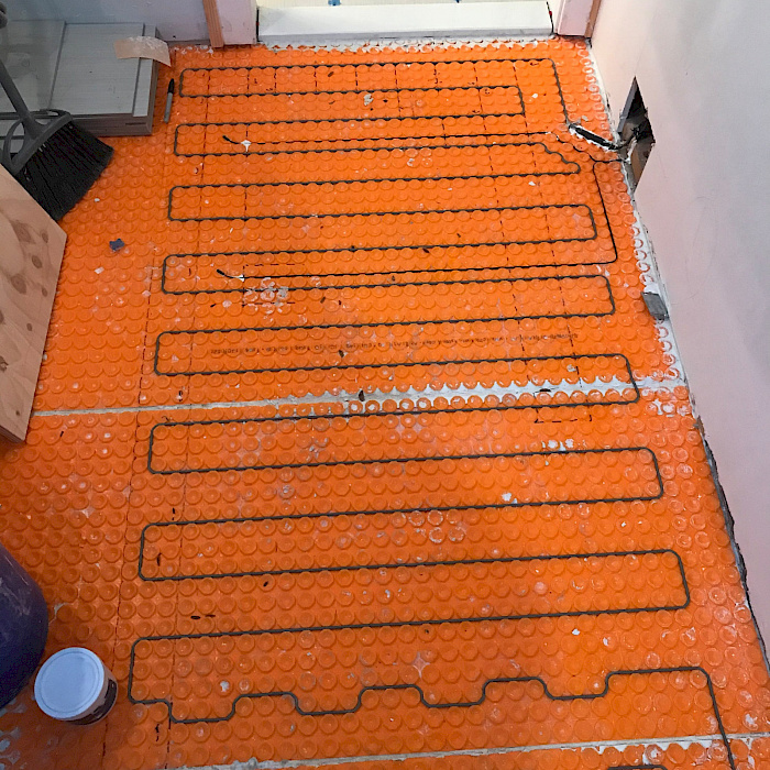 Uncoupling membrane installed under a heated bathroom tile floor by Sparrow Contracting
