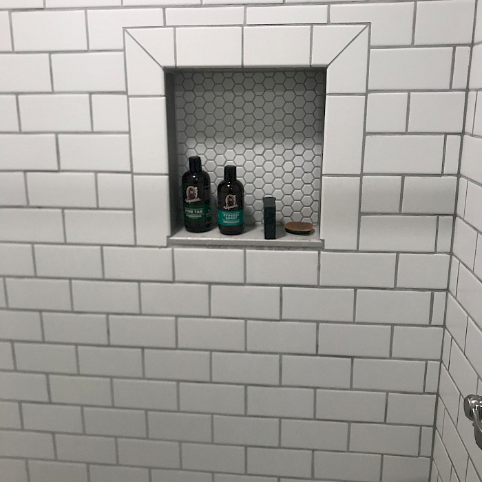 White subway tile shower with a built-in niche by Sparrow Contracting