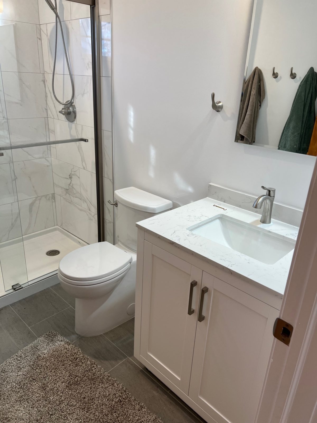 Bathroom remodel with marble vanity and glass shower