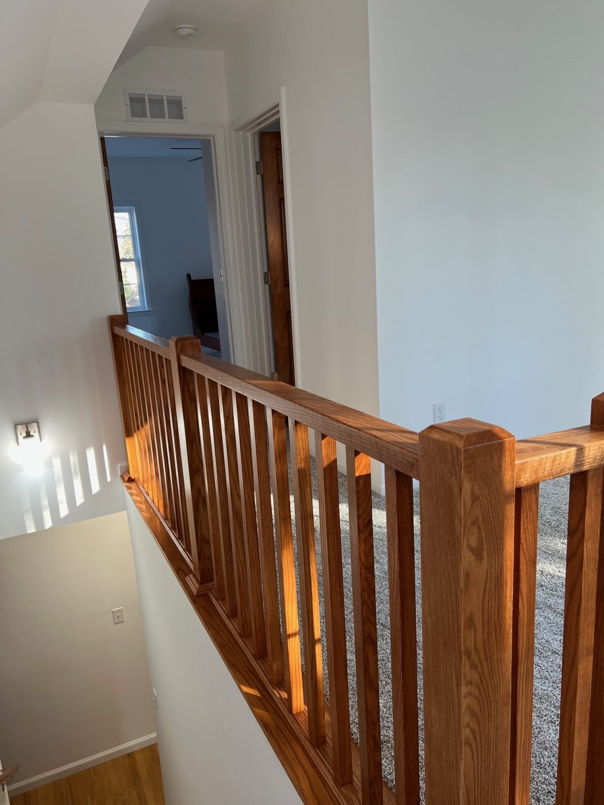 Custom open staircase with stained wood railing by Sparrow Contracting