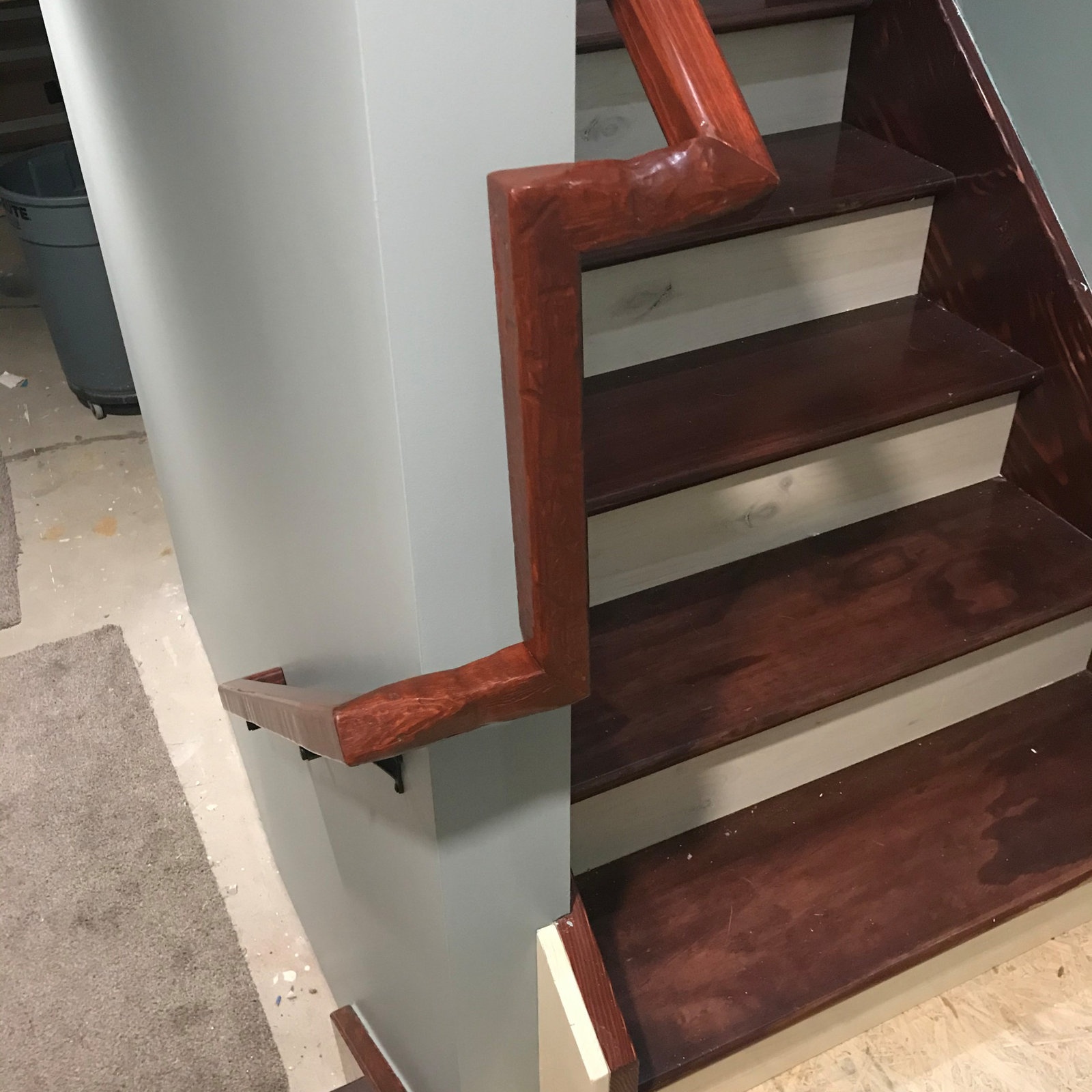 Stained wood stair treads and handrail installed by Sparrow Contracting in Fenton, Michigan
